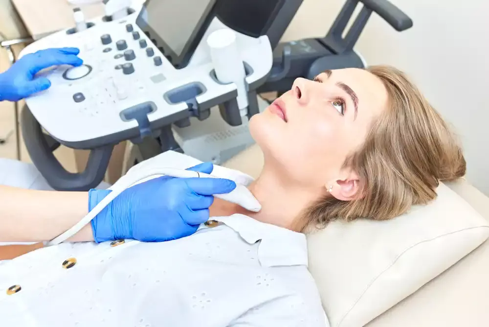 woman receiving thyroid ultrasound to see if she has hyperthyroidism